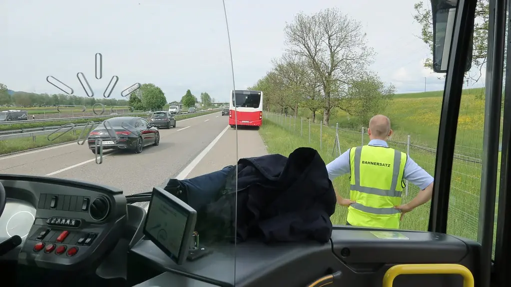 Vairuotojas su atšvaitine liemene greitkelio kelkraštyje