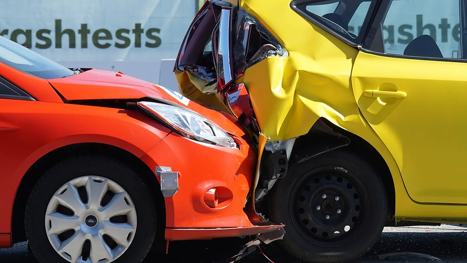 Susidūrę oranžinis ir geltonas automobiliai su sulamdytais kėbulais